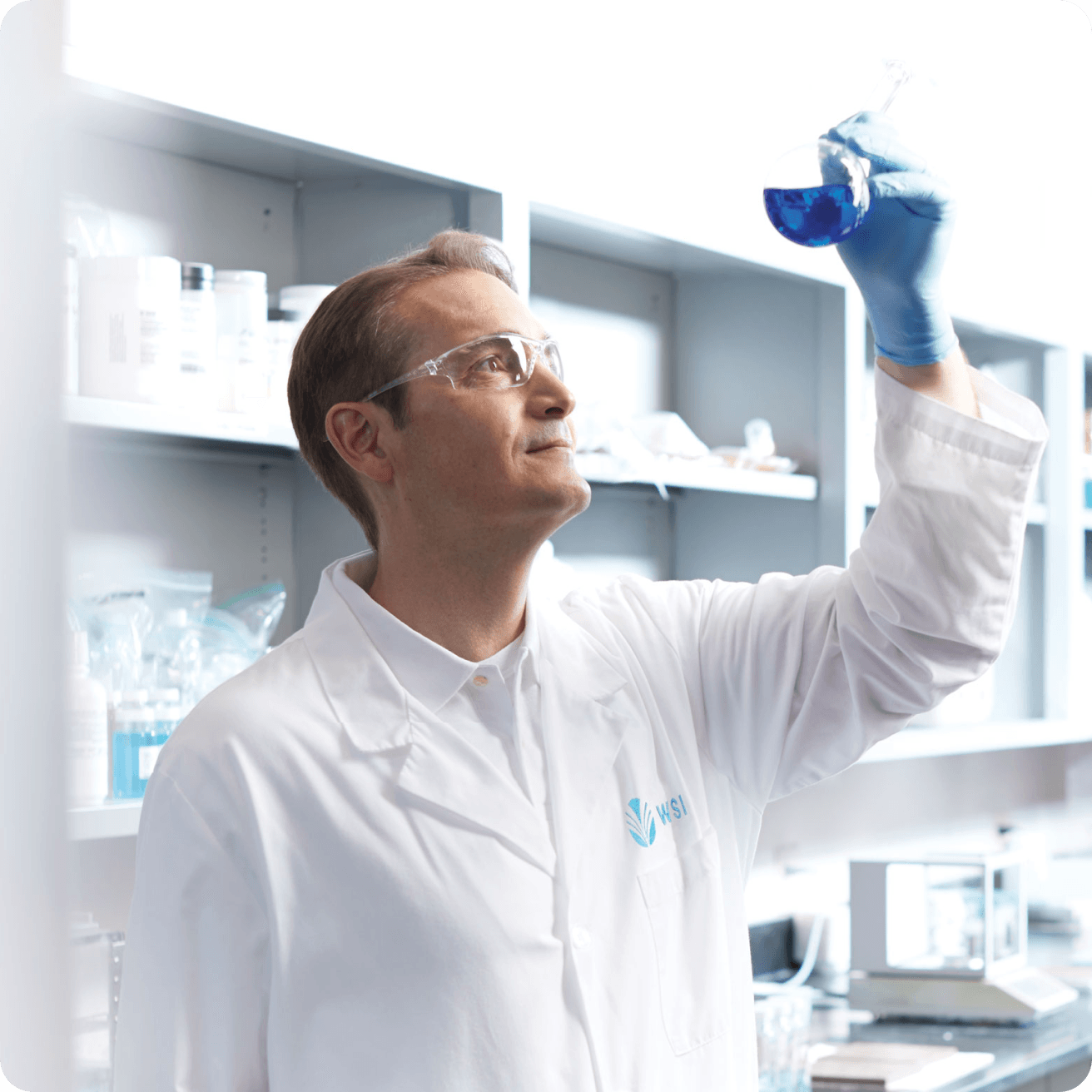 WSI scientist in laboratory examining blue chemical solution